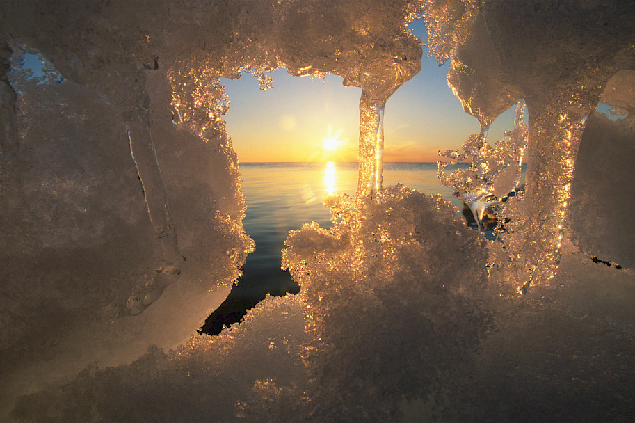 Sun and ocean viewed through melting ice