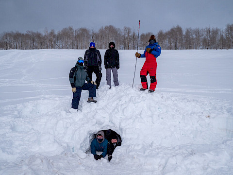 Researchers pose by a artificial den constructed for test purposes in Utah.