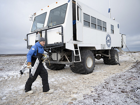 BJ Kirschhoffer carrying a ladder while he works on Tundra Buggy One - Jenny Wong
